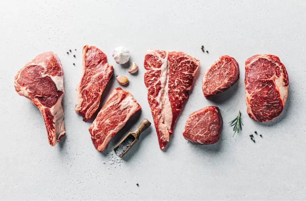 Assorted raw beef cuts on a light background