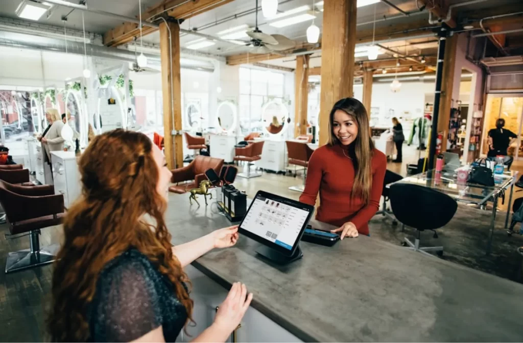 A customer interacting with a receptionist at a modern salon.