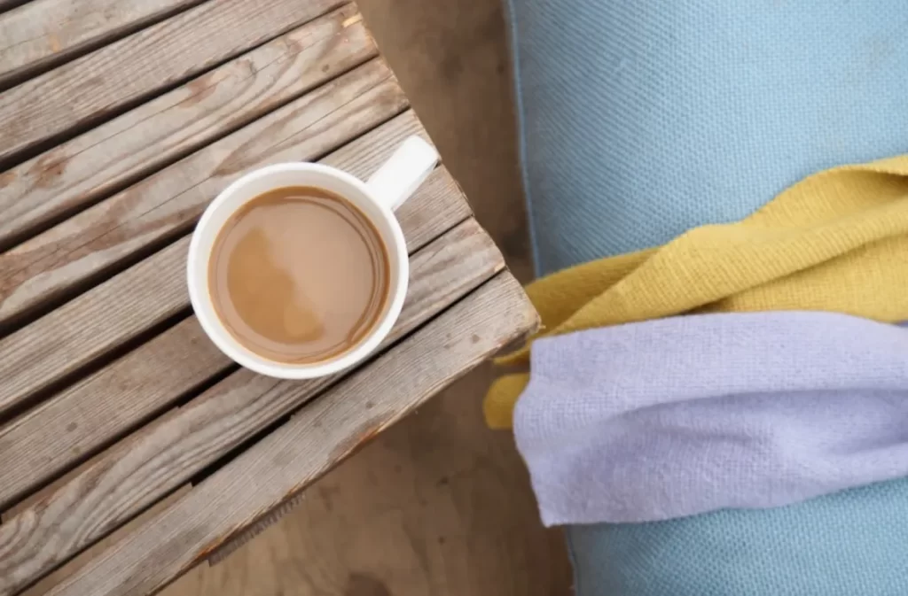 Cup of coffee on rustic wooden table – shop coffee tables on sale.