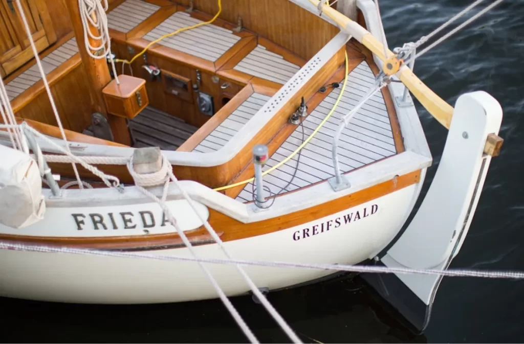 The wooden deck of a sailboat named Frieda.
