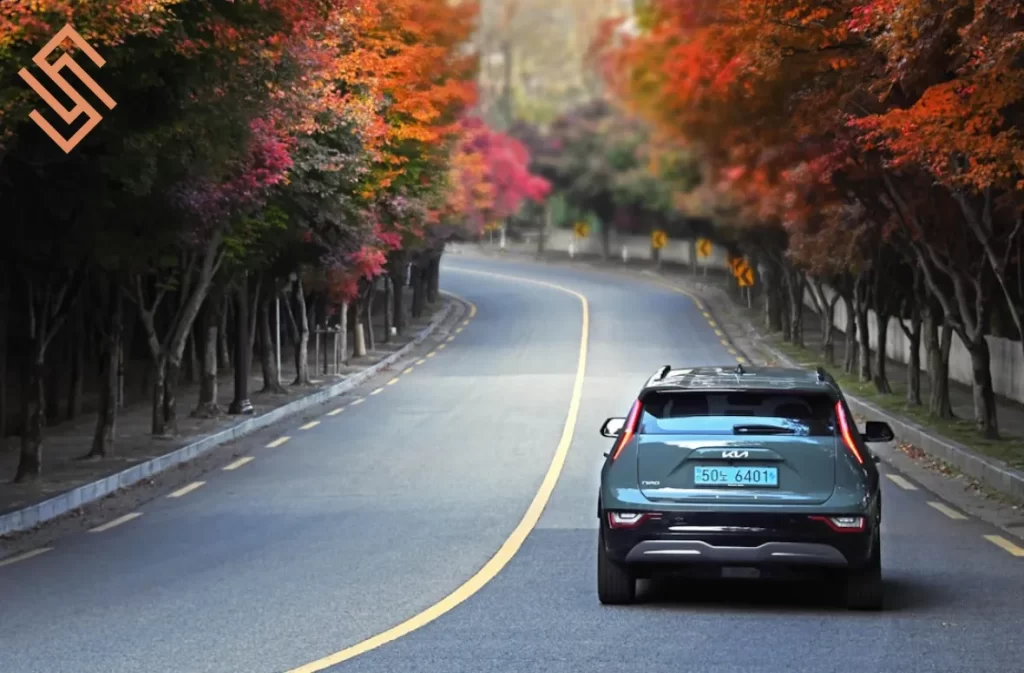 Kia SUV on a scenic autumn road, perfect for adventures.