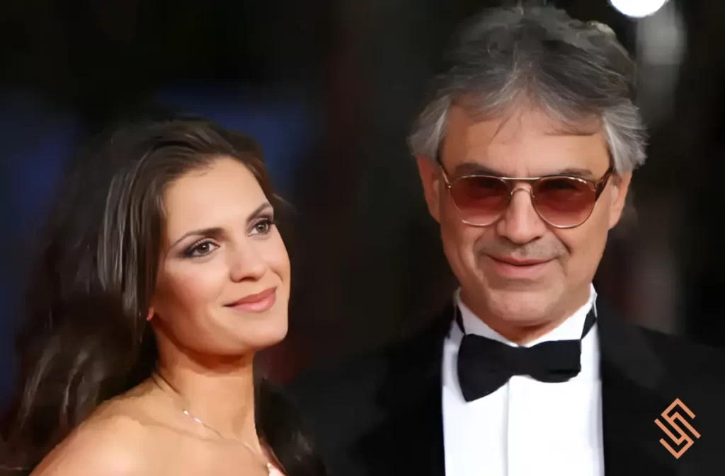 Andrea Bocelli and a woman on the red carpet in elegant outfits.