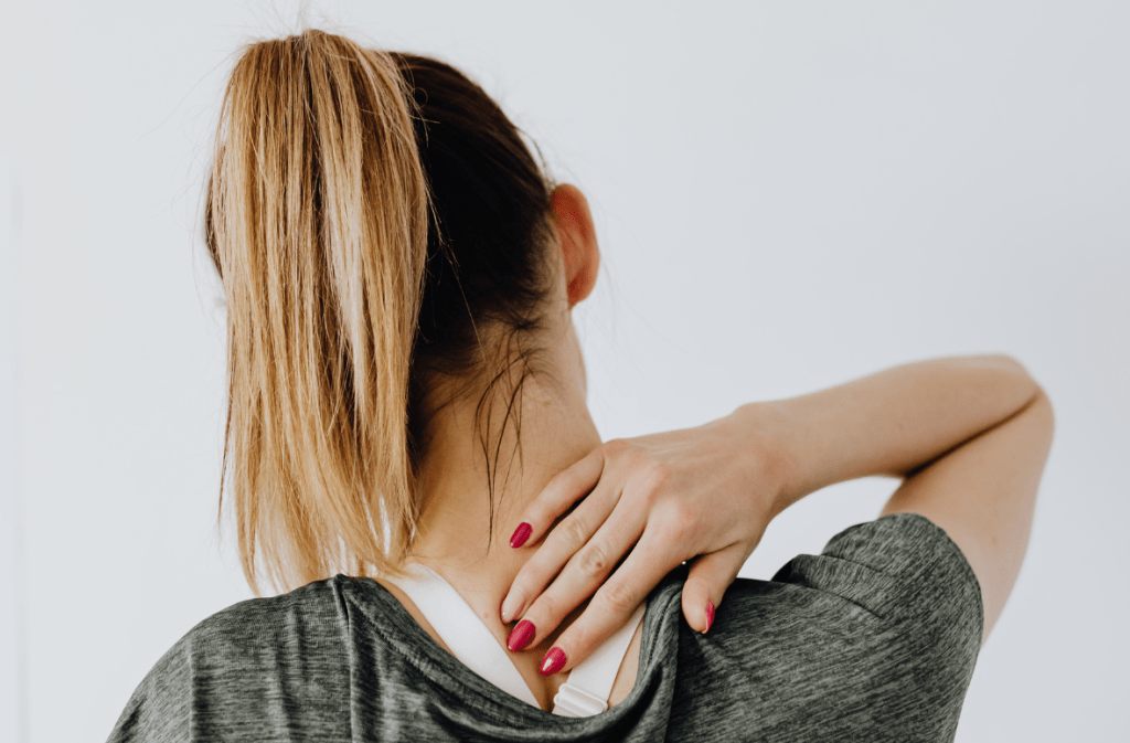 Woman gently massaging her neck to ease stiffness