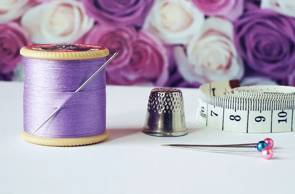 Purple thread spool with needle inserted.