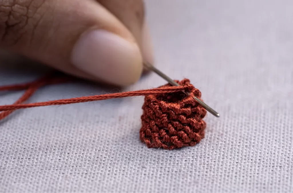 Close-up of threading with red embroidery thread.